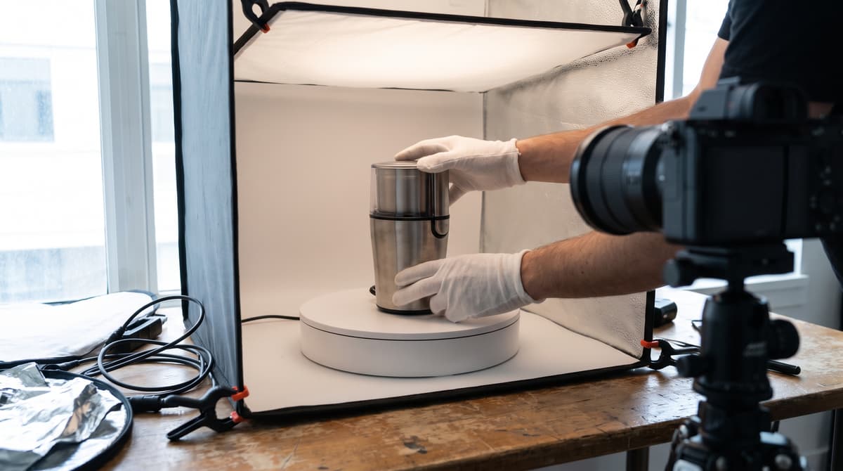 A merchandiser photographing a product on a turntable lightbox, building detailed catalog data for an e-commerce listing